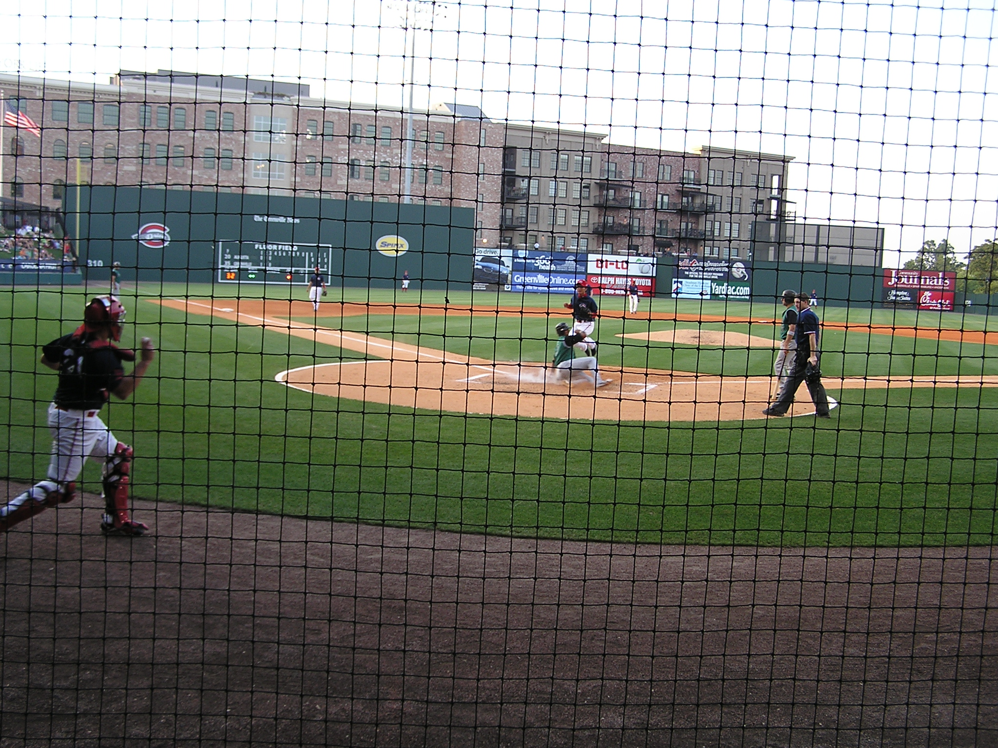 Safe! An opposing run scores at Fluor Field